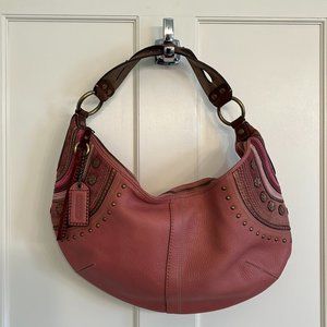 Coach mauve pink hobo bag with decorative stitching and brushed brass rivets
